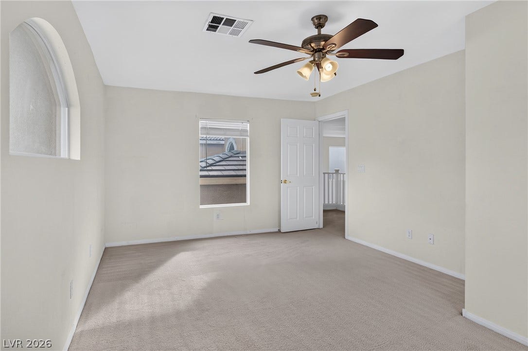 4871 Lionesse Court, Las Vegas, NV 89130 A spacious secondary bedroom features neutral wall tones and soft carpeting.