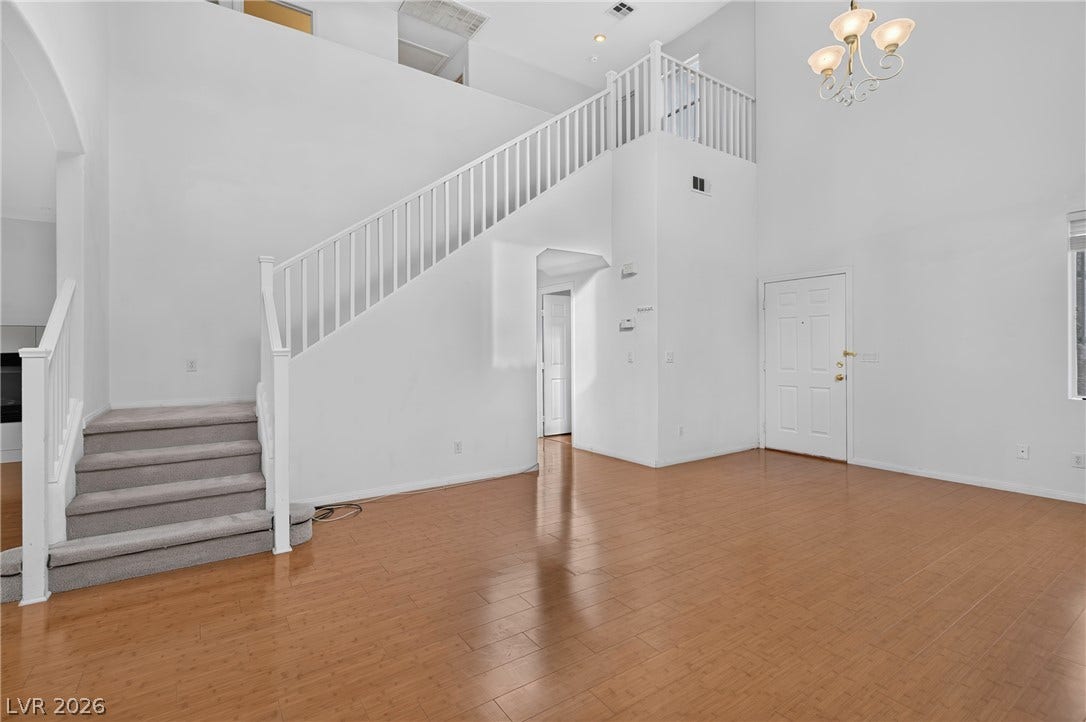 4871 Lionesse Court, Las Vegas, NV 89130 Polished hardwood floors and towering vaulted ceilings define this welcoming front entryway.