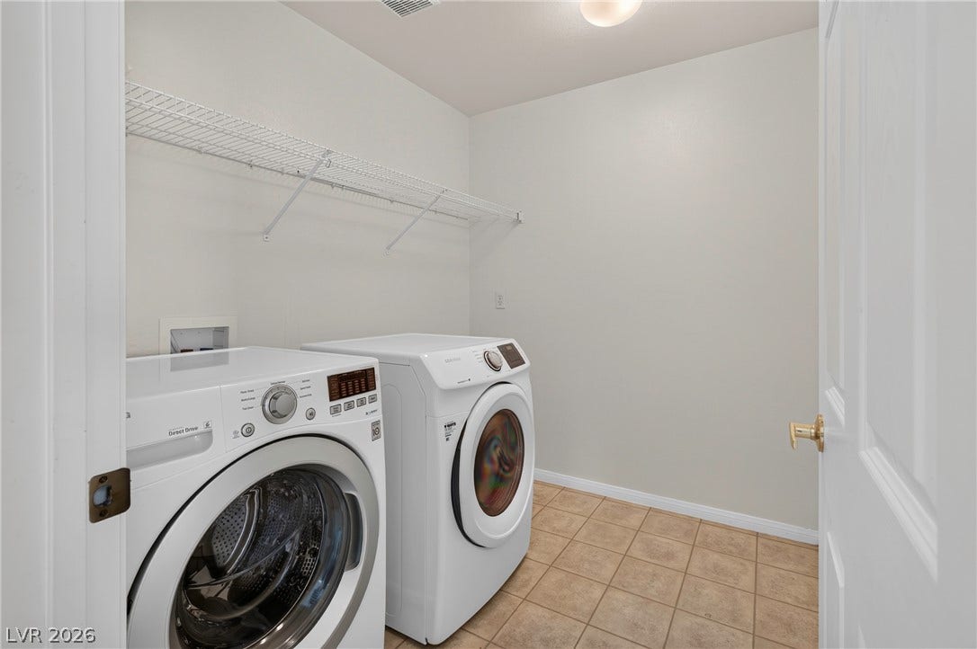 4871 Lionesse Court, Las Vegas, NV 89130 Tiled flooring and built-in shelving define this functional laundry utility area.