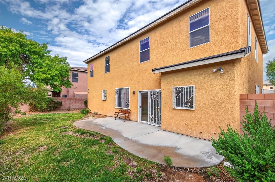 4871 Lionesse Court, Las Vegas, NV 89130 A concrete patio extends from the stucco exterior into a grassy backyard.
