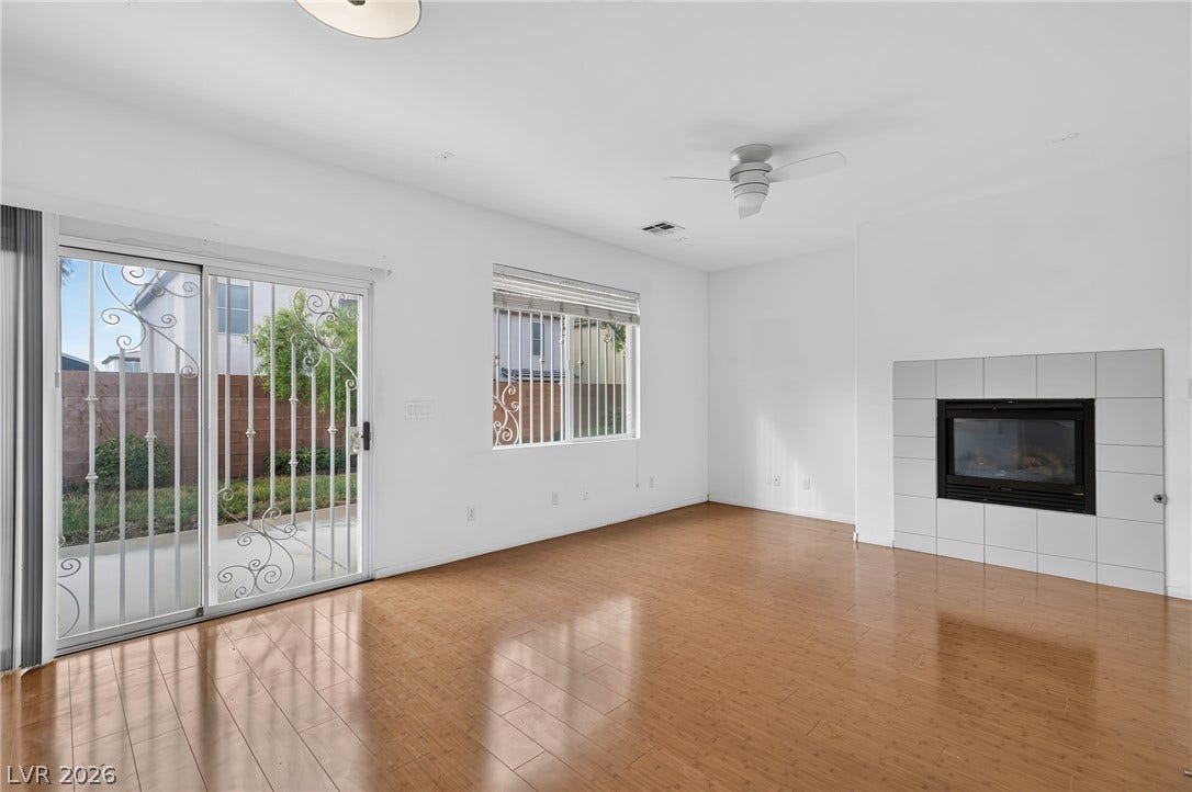 4871 Lionesse Court, Las Vegas, NV 89130 Polished hardwood floors and a modern tiled fireplace anchor this airy living space.