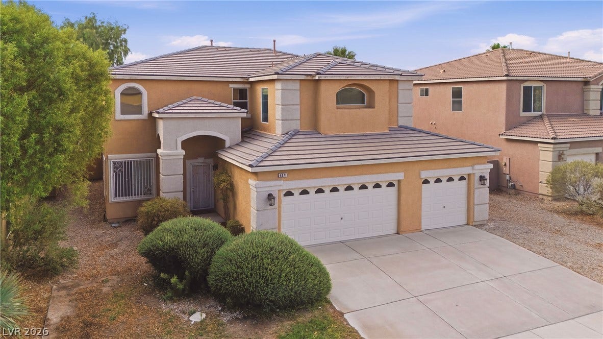 4871 Lionesse Court, Las Vegas, NV 89130 Spanish tile roofing and a multi-car garage define this classic suburban exterior.