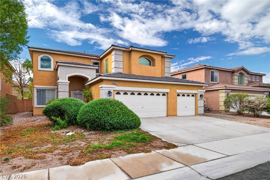 4871 Lionesse Court, Las Vegas, NV 89130 An inviting stucco exterior features prominent arched windows and a spacious concrete driveway.