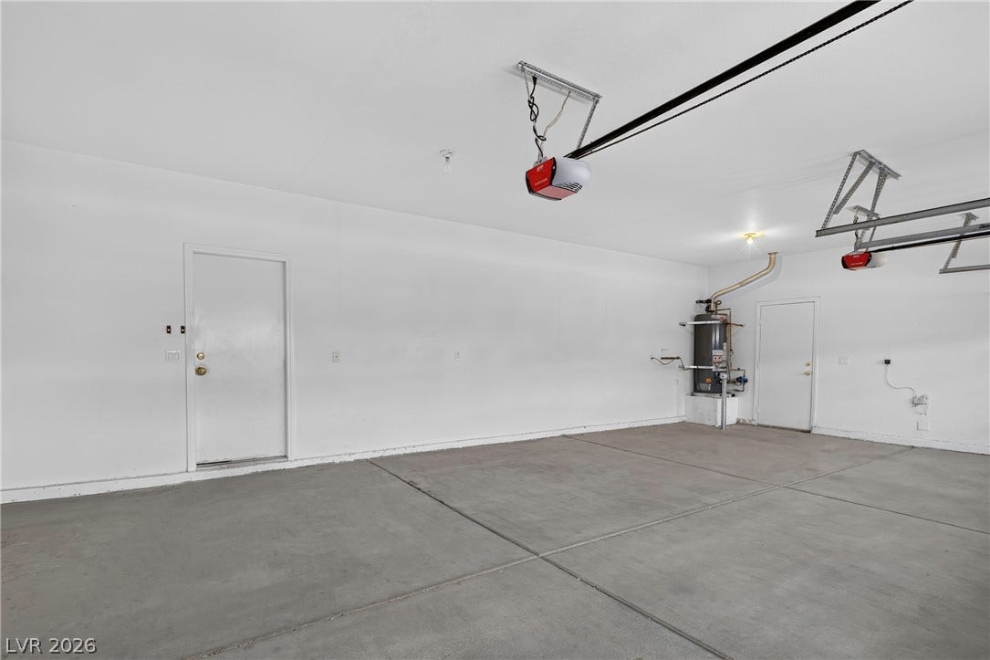 4871 Lionesse Court, Las Vegas, NV 89130 A spacious garage displays finished walls and a clean concrete floor.