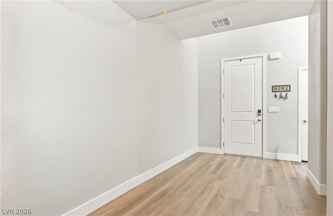 An inviting entryway with high ceilings and durable wood-look flooring creates a pleasant first impression.