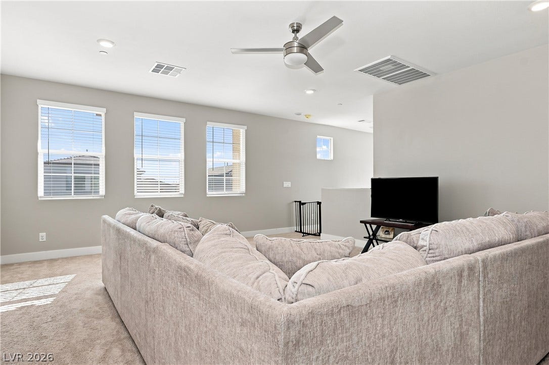 Plentiful natural light streams through multiple windows into this carpeted upstairs loft space.