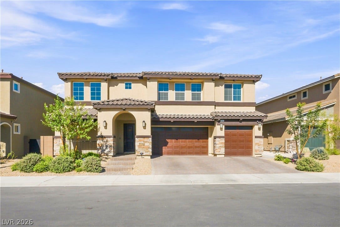 Spanish tile roofing and stone accents define this modern multi-level residence with integrated garages.