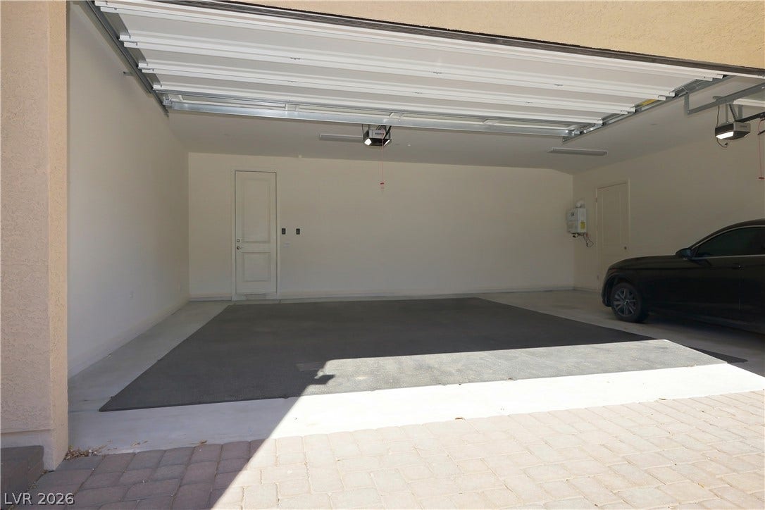 An attached three-car garage provides extensive concrete flooring and direct interior entry doors.