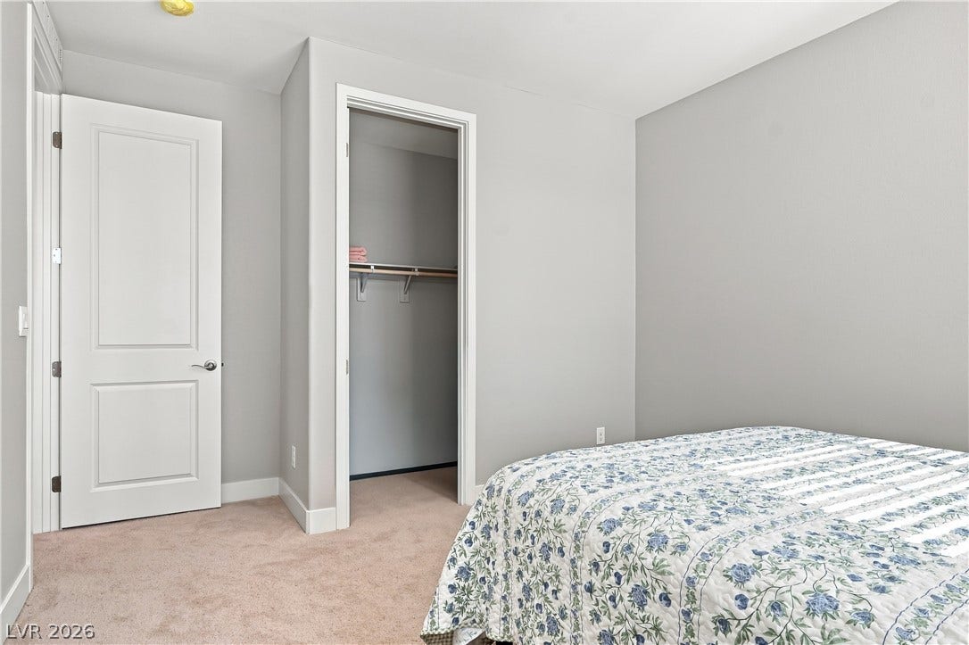Smooth walls and classic carpeting define this comfortable secondary bedroom.