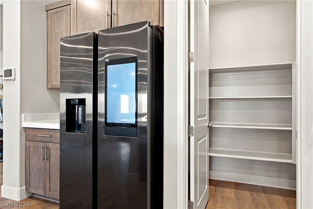 Ample built-in shelving maximizes storage potential in this walk-in kitchen pantry.