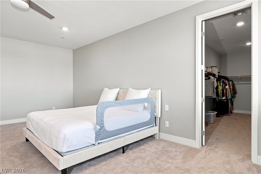 A spacious bedroom offers plush carpeting and a direct entrance to a walk-in closet.