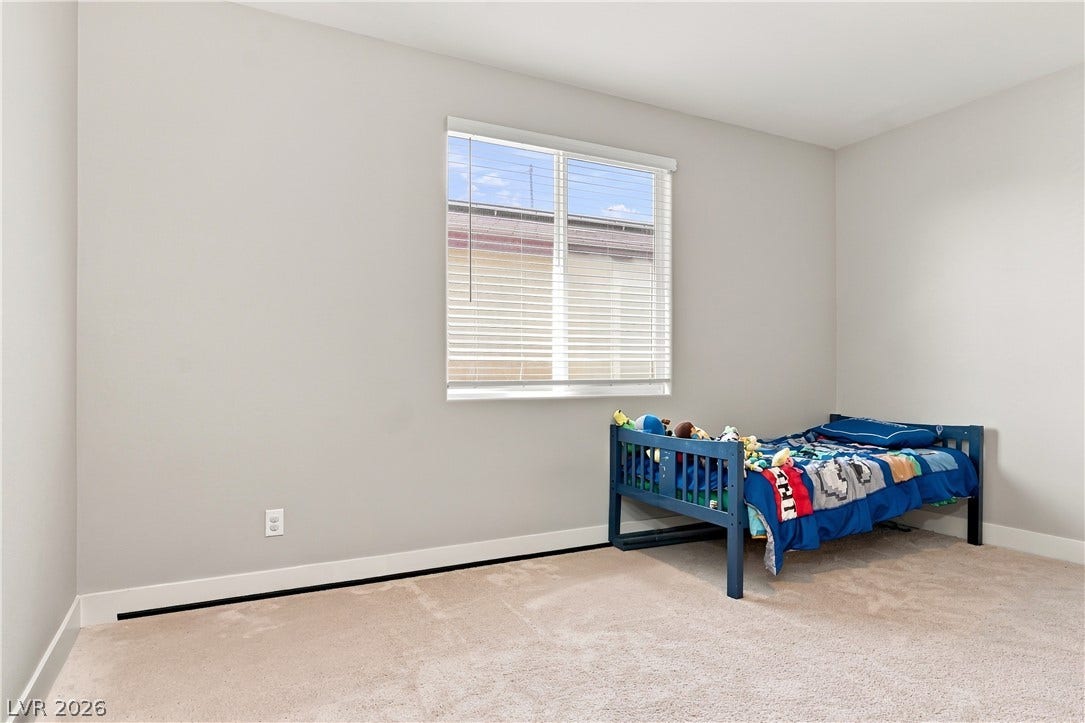 Plush carpet and a large window create a comfortable and inviting atmosphere.