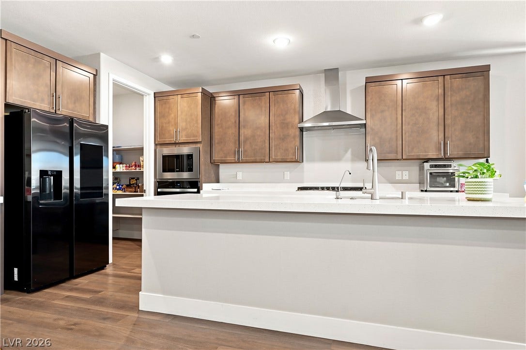 Ample counter space and timeless wood cabinetry define this modern culinary workspace.