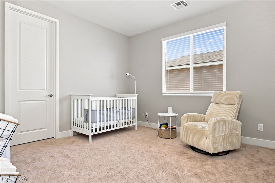 A window overlooks the neighborhood from this quiet bedroom featuring carpeted flooring.