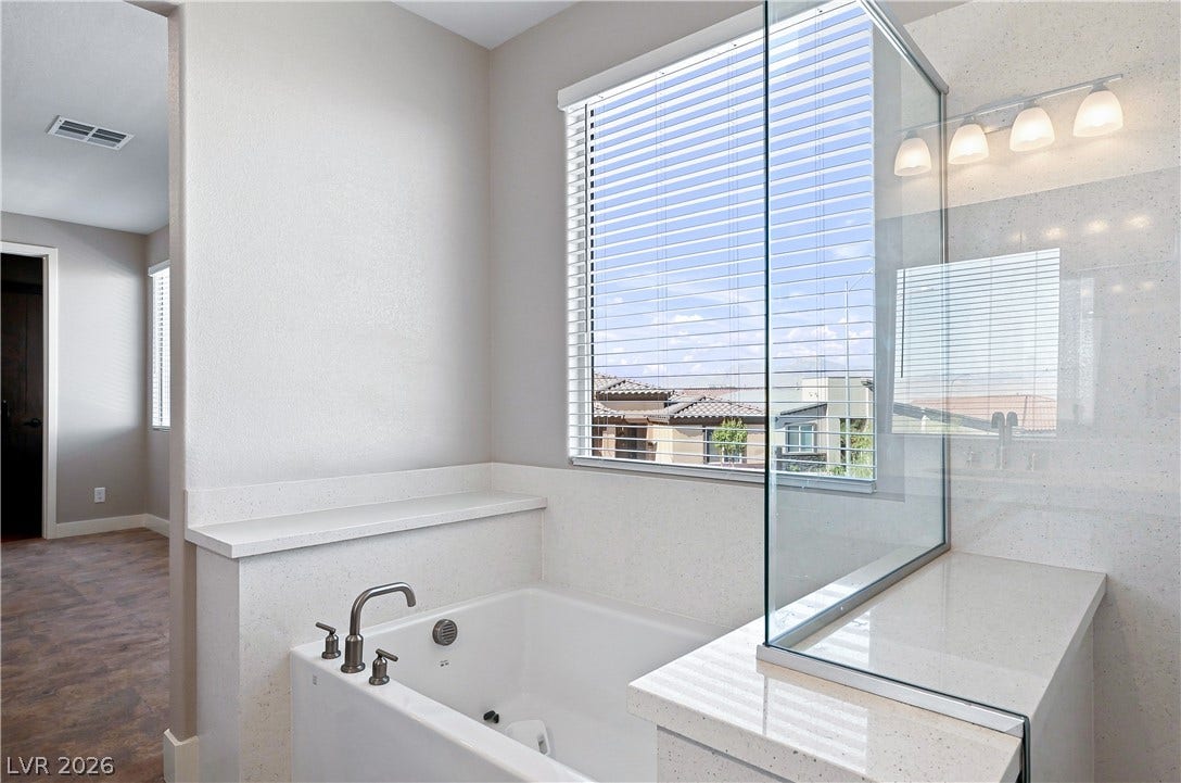 Clean lines and a spacious soaking tub highlight this contemporary primary bathroom.