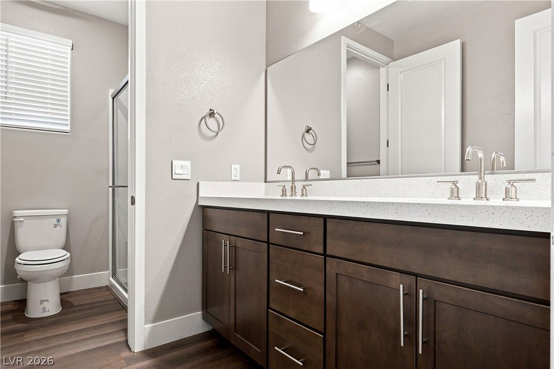 A spacious double vanity anchors this modern bathroom with its clean architectural lines.