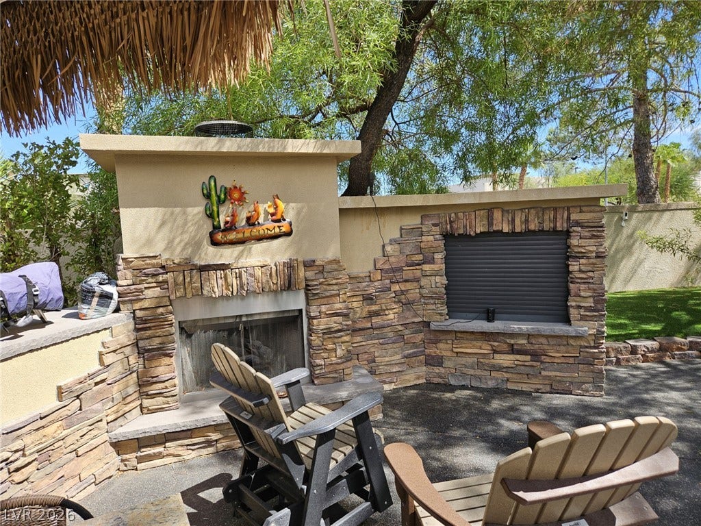 8175 Arville Street, #32, Las Vegas, NV 89139 An inviting outdoor stone fireplace serves as a focal point for this backyard patio space.