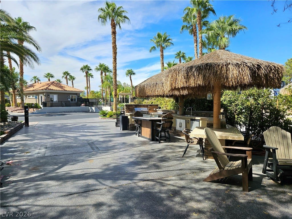 8175 Arville Street, #32, Las Vegas, NV 89139 An outdoor kitchen area with thatched palapas sits alongside a paved parking pad.