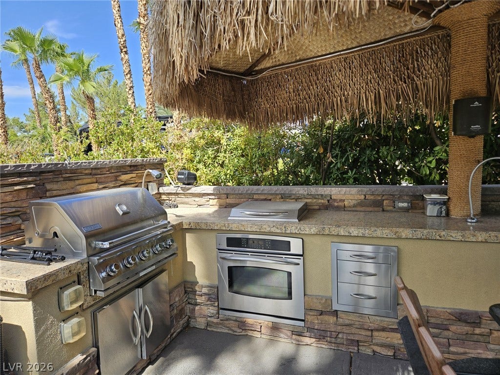 8175 Arville Street, #32, Las Vegas, NV 89139 An outdoor kitchen features stone accents and a thatched roof cover.