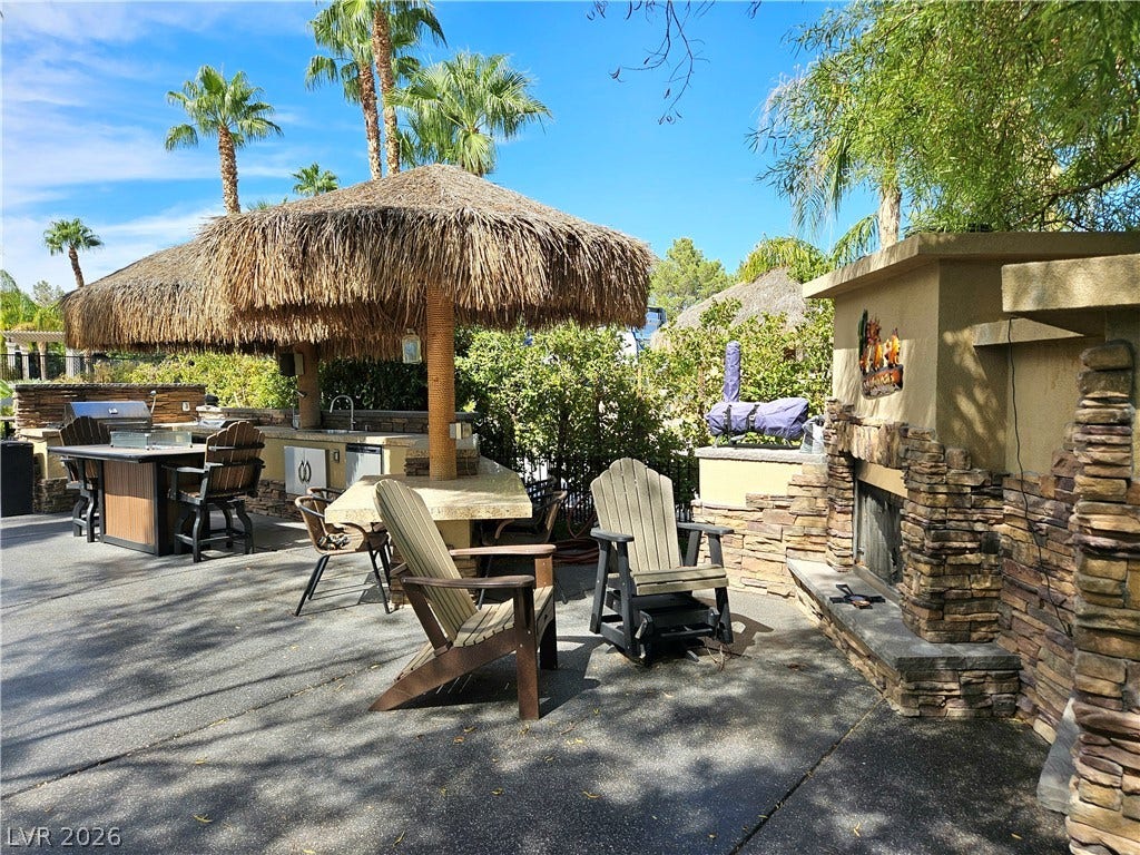 8175 Arville Street, #32, Las Vegas, NV 89139 Stone accents and a built-in outdoor fireplace enhance this resort-style backyard patio.