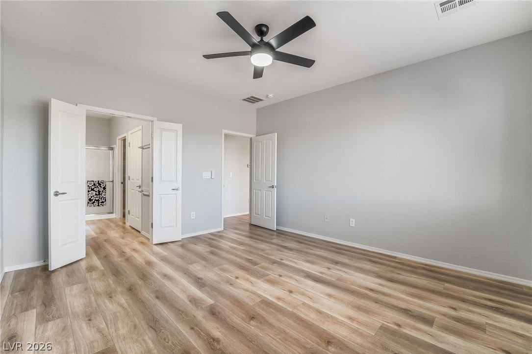 Primary bedroom with double doors leading to the primary bathroom