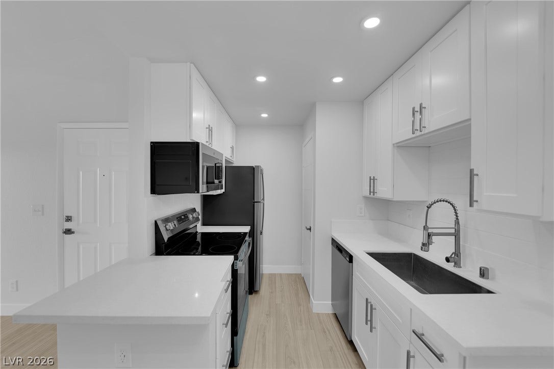 5111 Lindell Road, #202, Las Vegas, NV 89118 Bright white cabinetry and stone counters define this modern workspace.
