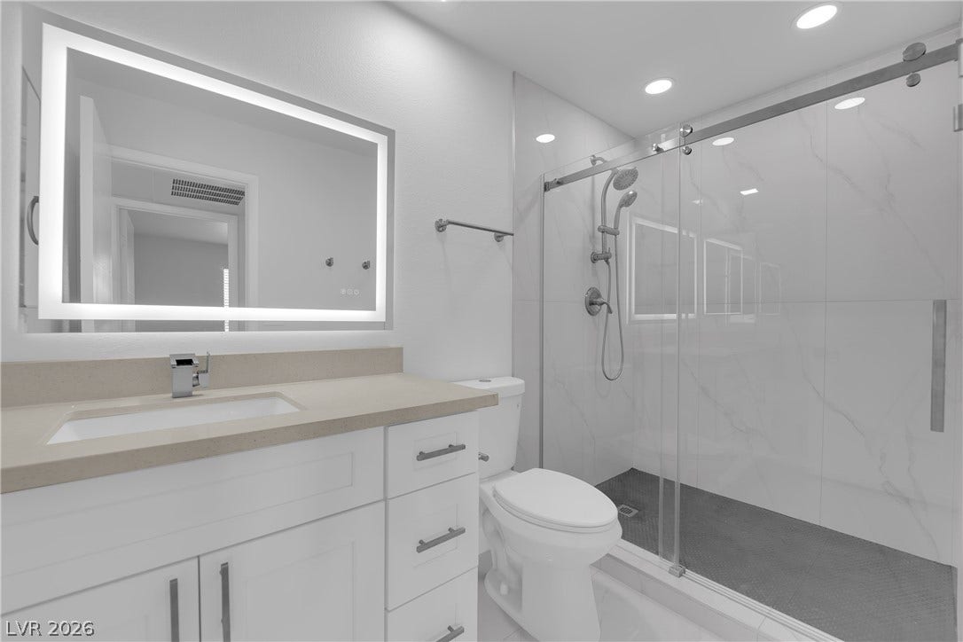5111 Lindell Road, #202, Las Vegas, NV 89118 Recessed lighting and a glass-enclosed walk-in shower elevate this sleek modern bathroom.