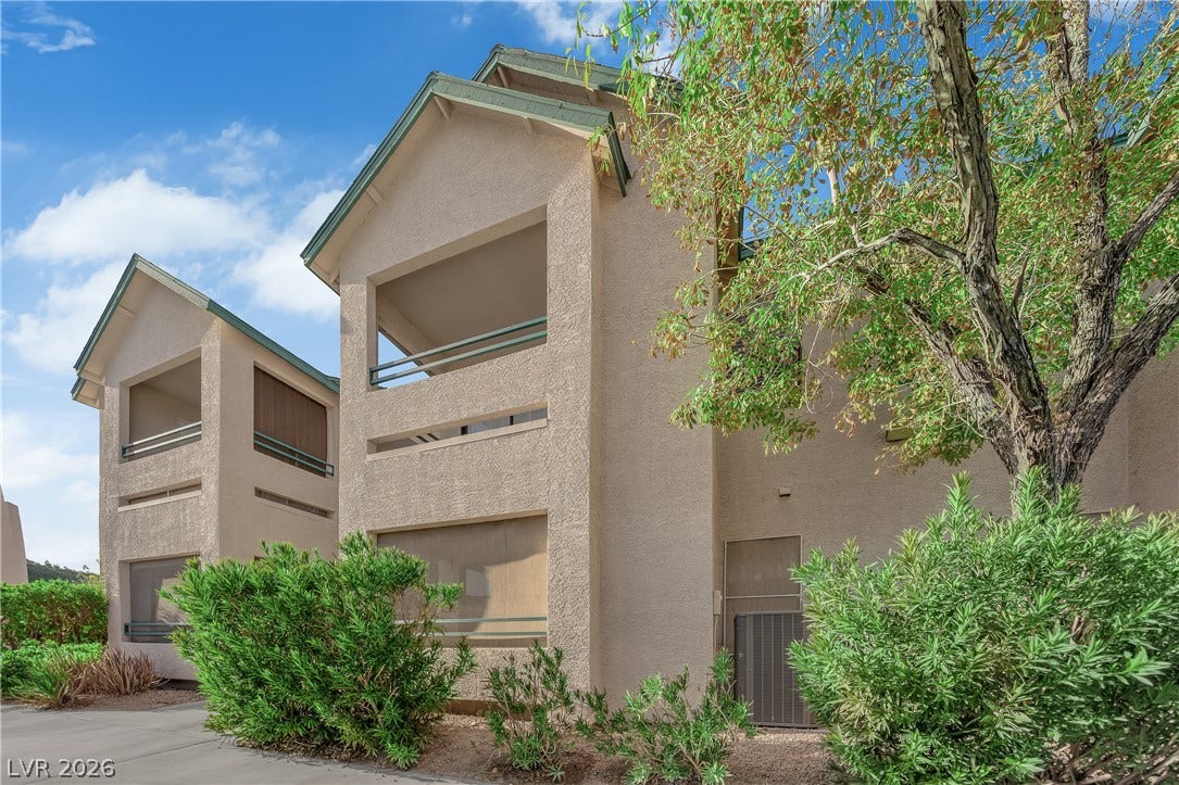 5111 Lindell Road, #202, Las Vegas, NV 89118 Multi-level stucco exteriors feature private recessed balconies framed by leafy mature trees.