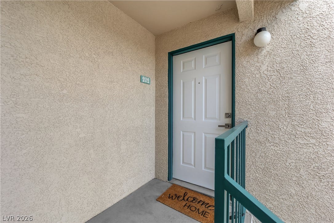 5111 Lindell Road, #202, Las Vegas, NV 89118 An inviting private entrance features textured stucco walls and concrete flooring.