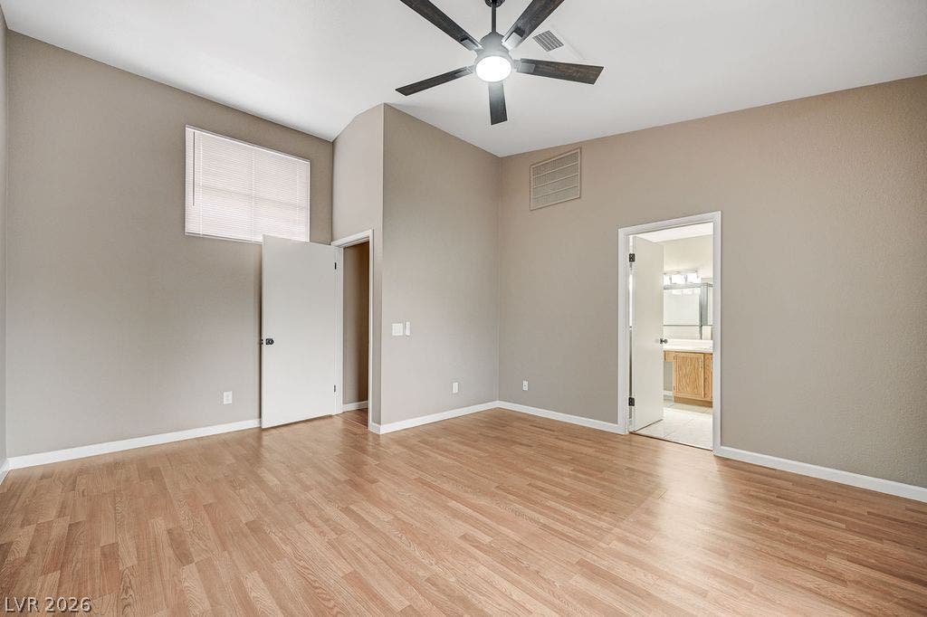 2191 Pinetop Lane, #104, Las Vegas, NV 89119 High ceilings and warm wood-look flooring enhance this inviting bedroom space.