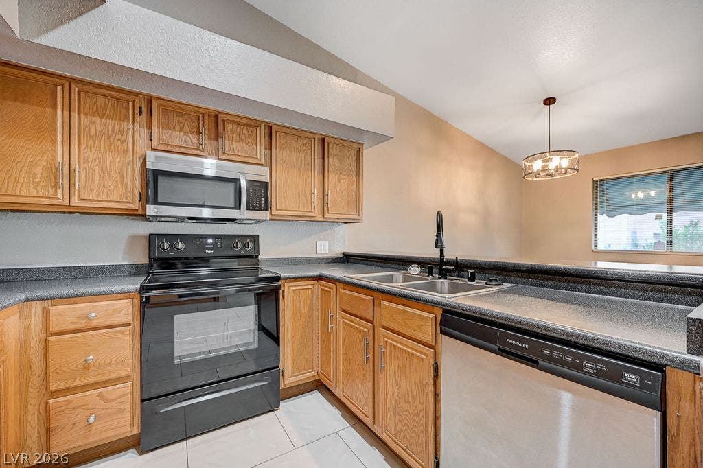 2191 Pinetop Lane, #104, Las Vegas, NV 89119 Warm oak cabinetry pairs with clean tile flooring in this functional kitchen space.