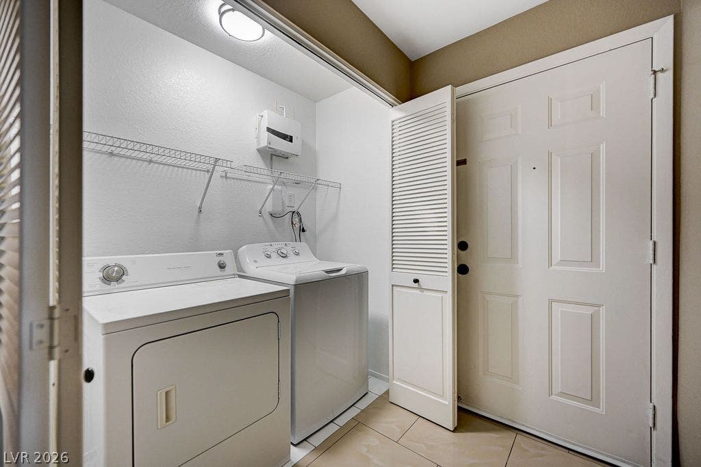 2191 Pinetop Lane, #104, Las Vegas, NV 89119 A functional laundry area with tile flooring sits conveniently near the main entry door.