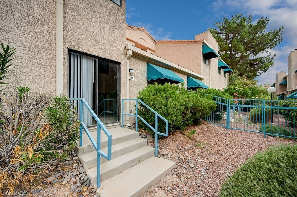 2191 Pinetop Lane, #104, Las Vegas, NV 89119 Stucco exterior featuring private entry steps, sliding glass doors, and prominent window awnings.