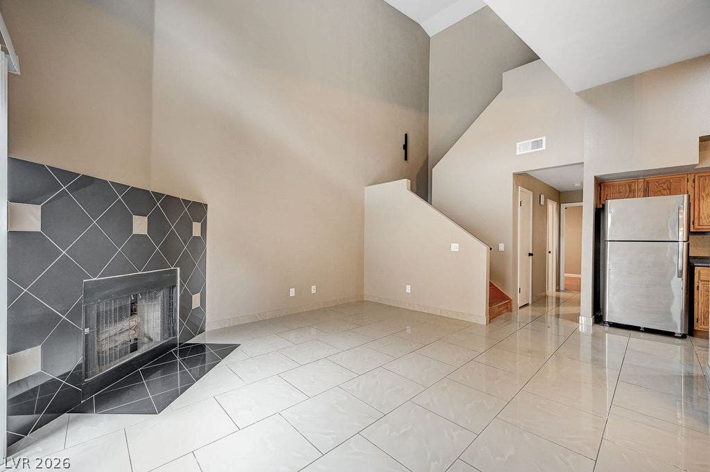 2191 Pinetop Lane, #104, Las Vegas, NV 89119 High ceilings and polished tile floors frame a striking fireplace in this open living area.