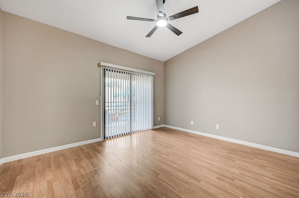 2191 Pinetop Lane, #104, Las Vegas, NV 89119 Sliding glass doors open to the outdoors, filling the wood-floored space with natural light.