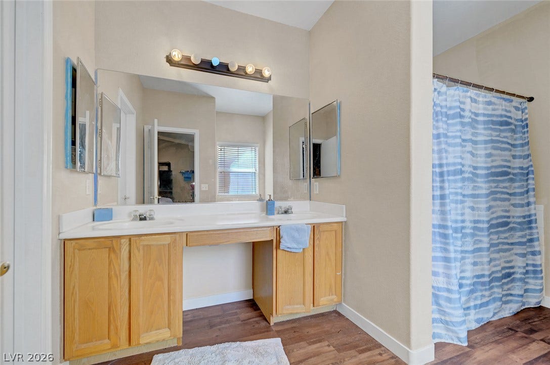 7450 S Eastern Avenue, #1064, Las Vegas, NV 89123 Rich wood-inspired flooring pairs with a expansive vanity area to create a functional bathroom space.