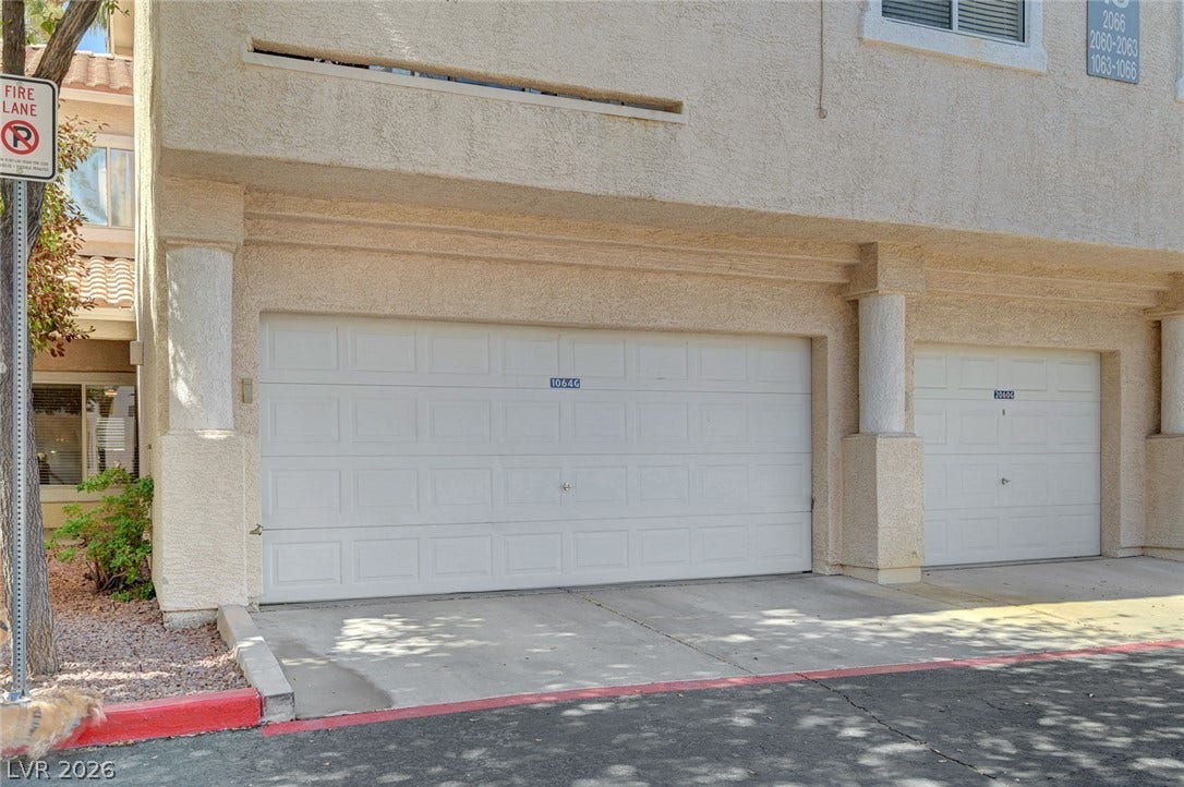 7450 S Eastern Avenue, #1064, Las Vegas, NV 89123 Integrated multi-car garages provide convenient parking and storage underneath the stucco townhouse structure.