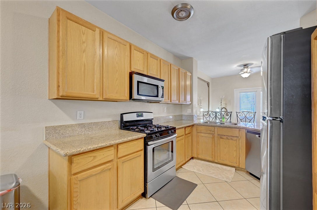 7450 S Eastern Avenue, #1064, Las Vegas, NV 89123 Ample wooden cabinetry and durable stone counters define this functional kitchen layout.