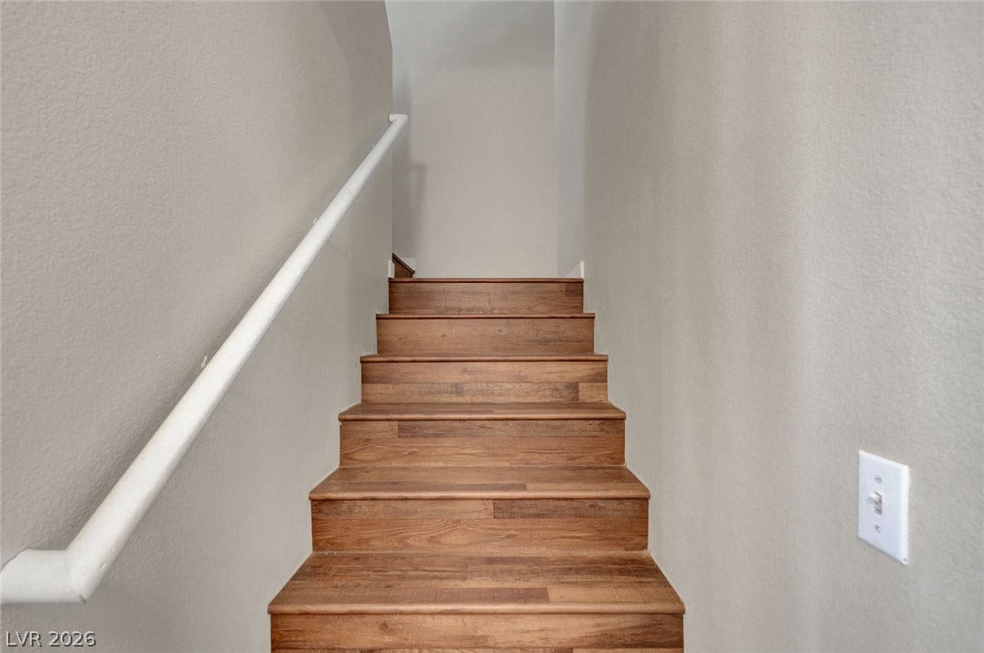 7450 S Eastern Avenue, #1064, Las Vegas, NV 89123 Rich wood steps rise between neutral walls to connect the living levels.