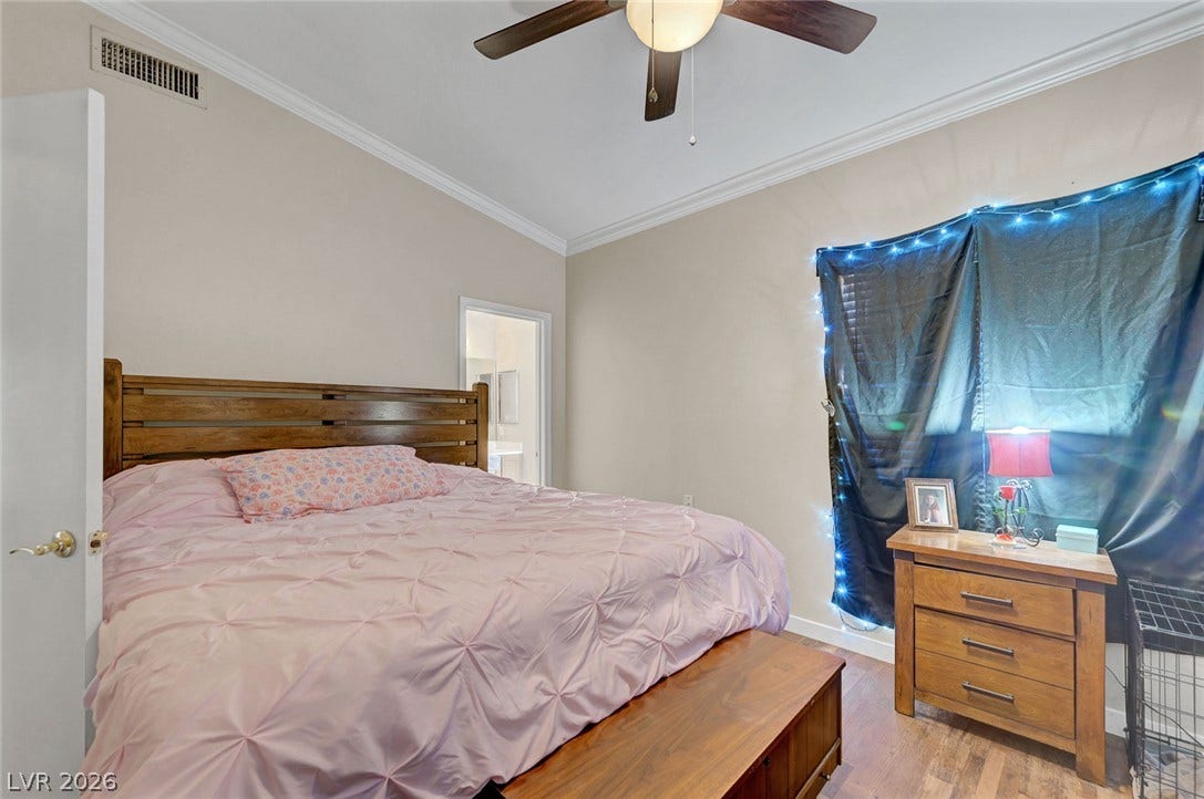 7450 S Eastern Avenue, #1064, Las Vegas, NV 89123 Crown molding accents the high ceiling of this bedroom featuring durable wood-look flooring.