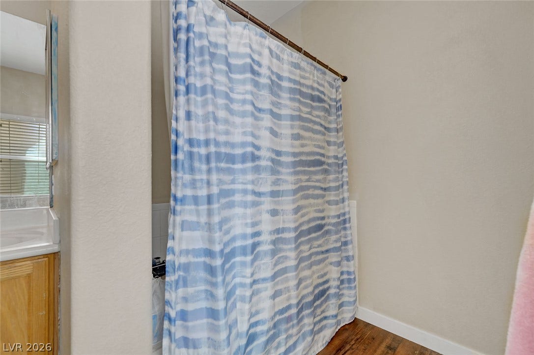 7450 S Eastern Avenue, #1064, Las Vegas, NV 89123 A classic shower setup features wood floors and neutral wall tones.