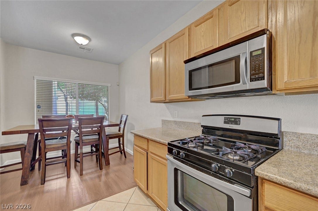 7450 S Eastern Avenue, #1064, Las Vegas, NV 89123 Functional kitchen design links wood cabinetry and stone counters directly to an adjoining dining space.