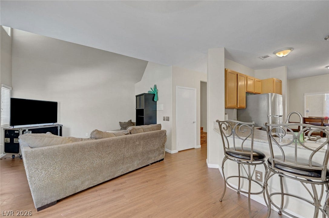 7450 S Eastern Avenue, #1064, Las Vegas, NV 89123 Smooth wood flooring flows seamlessly through this open-concept layout beneath towering vaulted ceilings.