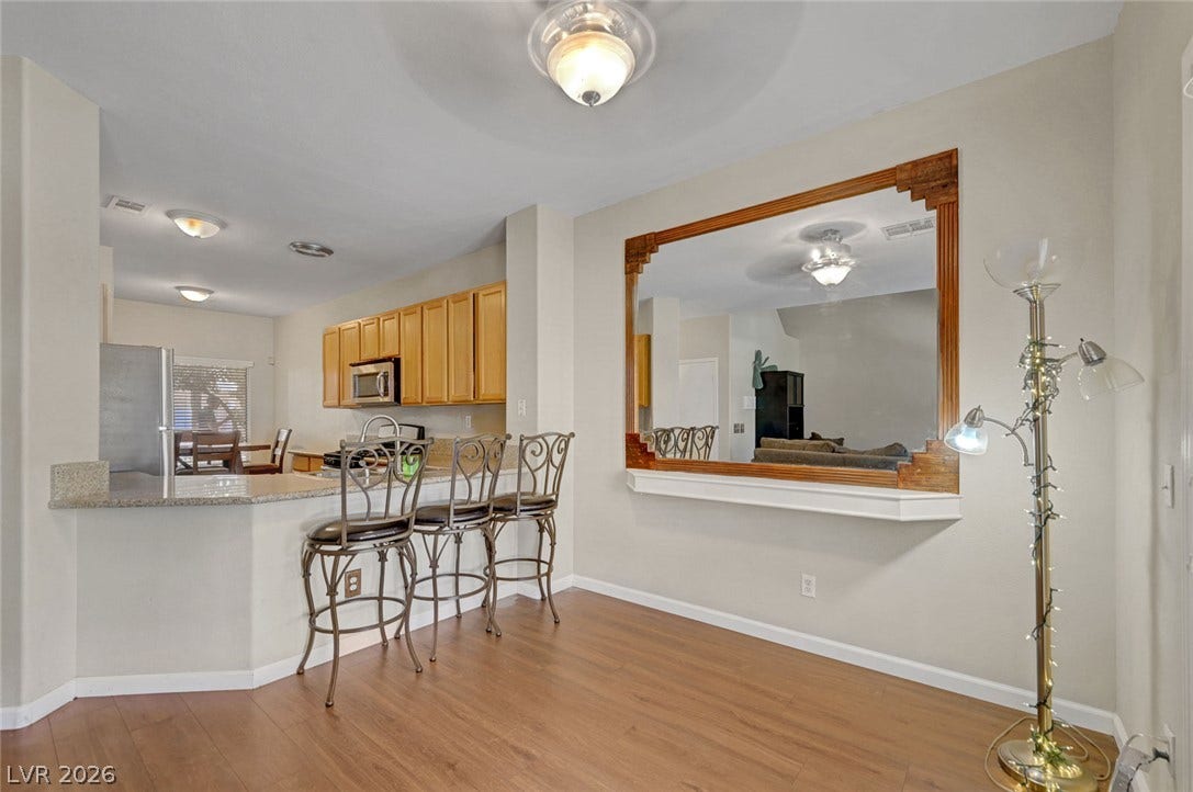 7450 S Eastern Avenue, #1064, Las Vegas, NV 89123 An open dining area features smooth laminate flooring and a wide pass-through window to the living space.