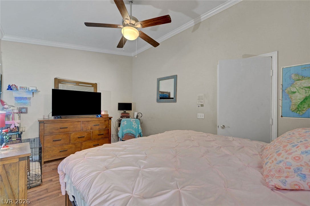 7450 S Eastern Avenue, #1064, Las Vegas, NV 89123 High ceilings with classic crown molding and warm wood floors define this comfortable bedroom.