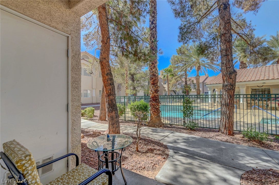 7450 S Eastern Avenue, #1064, Las Vegas, NV 89123 A private covered patio opens to a paved walkway leading directly toward the community pool.