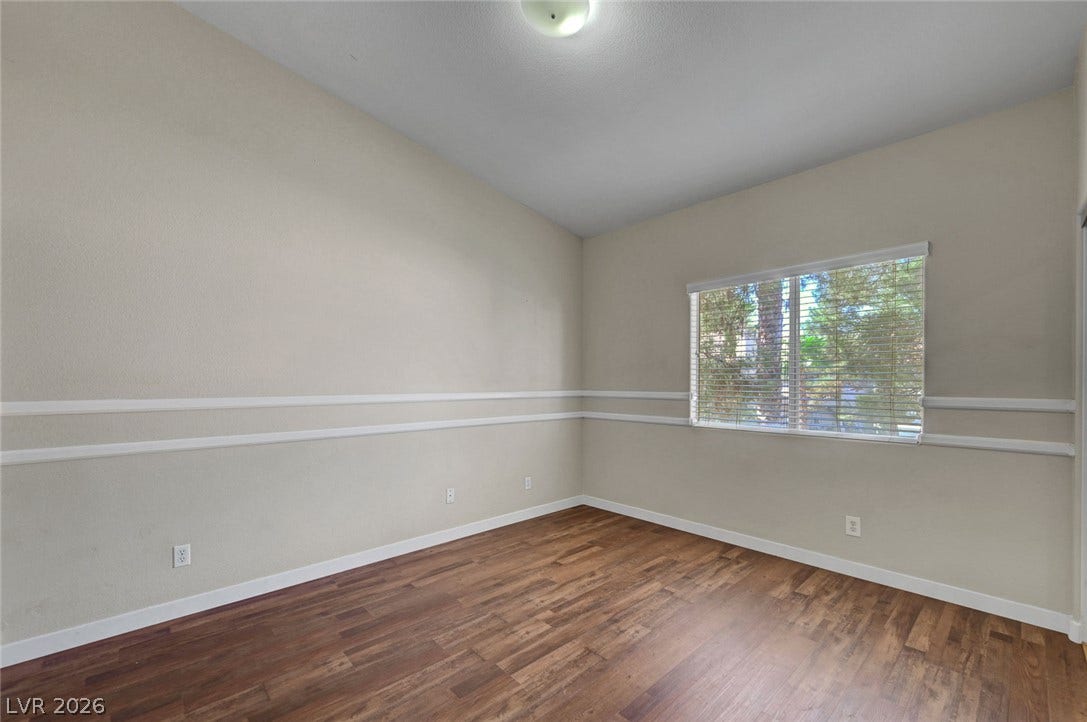 7450 S Eastern Avenue, #1064, Las Vegas, NV 89123 Rich wood-inspired flooring and classic chair rail molding define this versatile living space.