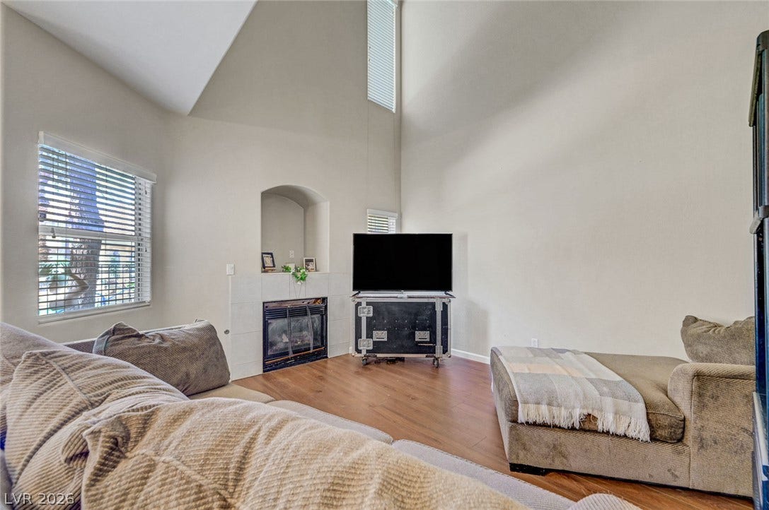 7450 S Eastern Avenue, #1064, Las Vegas, NV 89123 Vaulted ceilings soar over a corner fireplace and rich wood-inspired flooring.