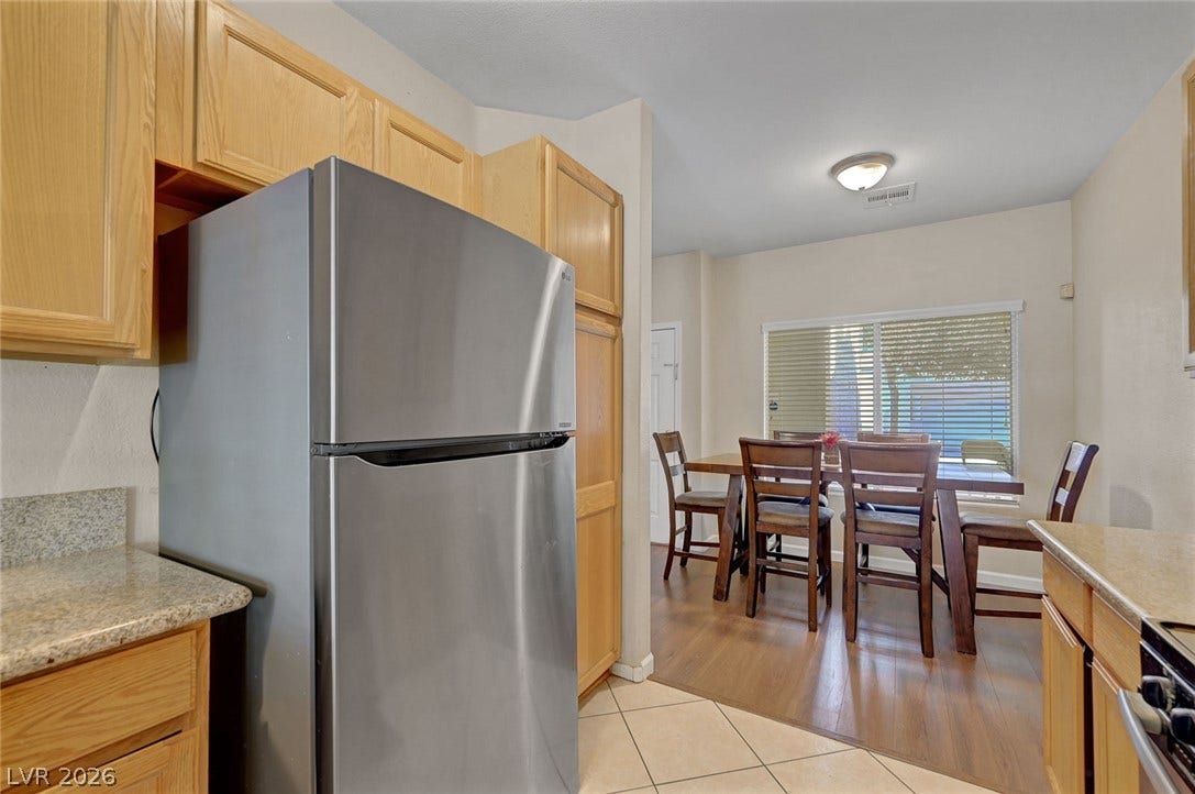 7450 S Eastern Avenue, #1064, Las Vegas, NV 89123 Gleaming stone countertops and classic wood cabinetry transition seamlessly into a bright dining area.
