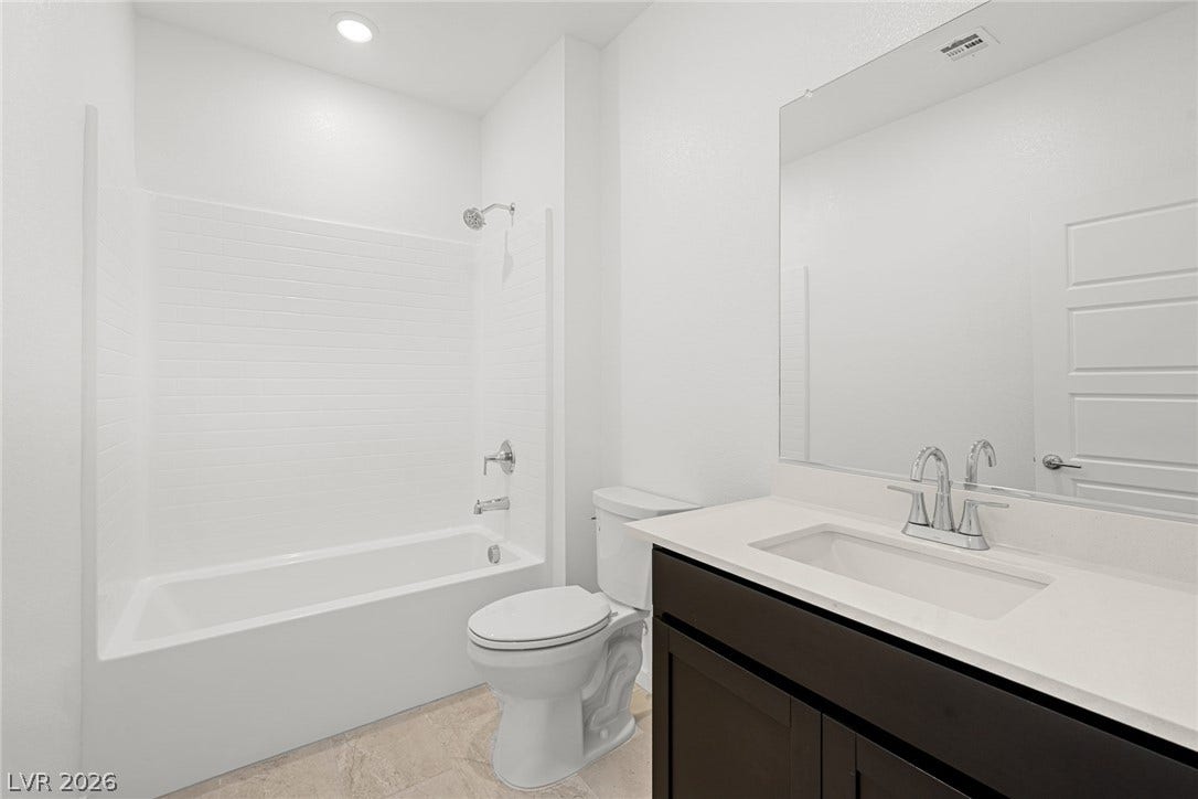 9568 Sagebrush Grove Street, Las Vegas, NV 89178 A crisp white tub enclosure and modern dark vanity highlight this contemporary bathroom layout.